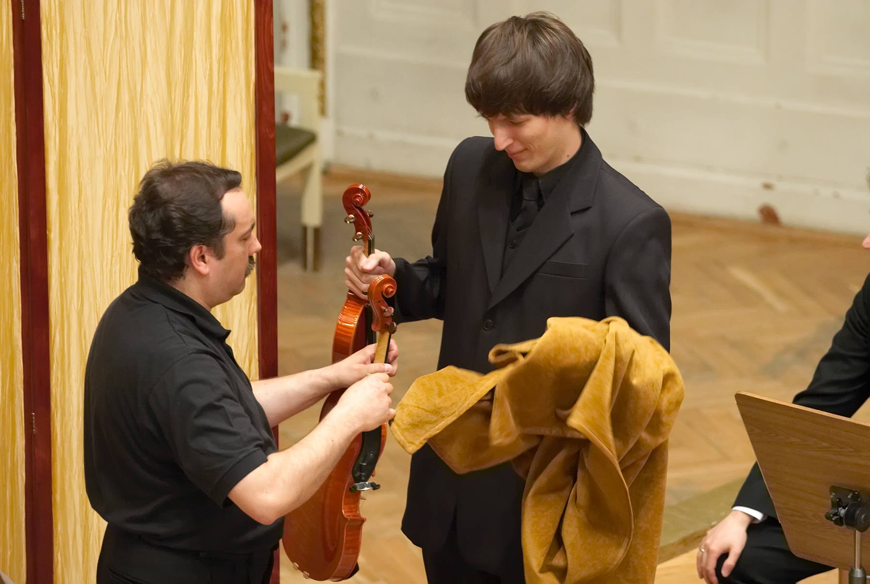 Bartosz Bryła receiving another violin to test at the final stage of the competition.
