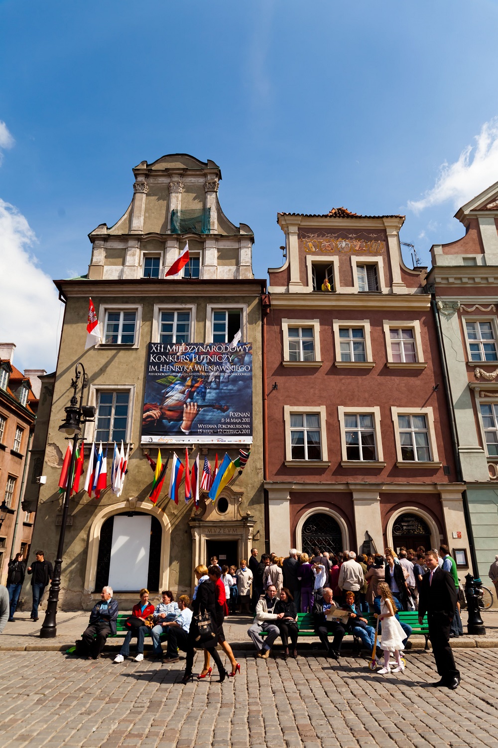 Muzeum Instrumentów Muzycznych przyozdobione flagami krajów, z których pochodzą biorący w nim udział lutnicy oraz bannerem prezentującym plakat wydarzenia autorstwa Rafała Olbińskiego.
