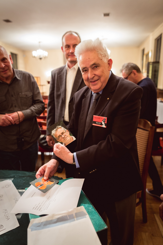 Opening envelopes containing names of violin makers. Andrzej Wituski - director of the Competition showing the picture of 3rd Prize Winner Philippe Mahu.